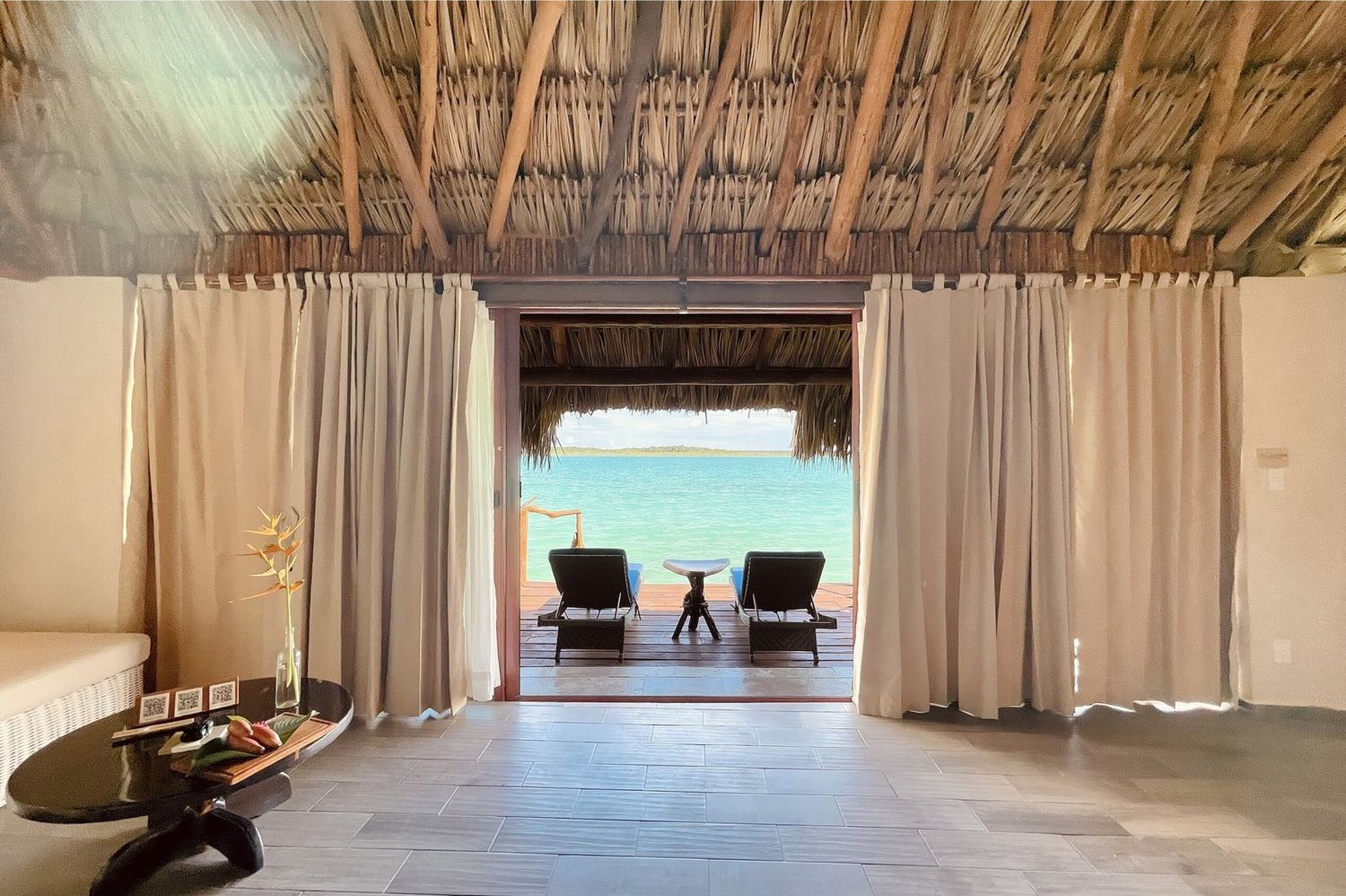 Vista desde el interior de un palafito de techo de palma hacia la Laguna de los Siete Colores en Bacalar