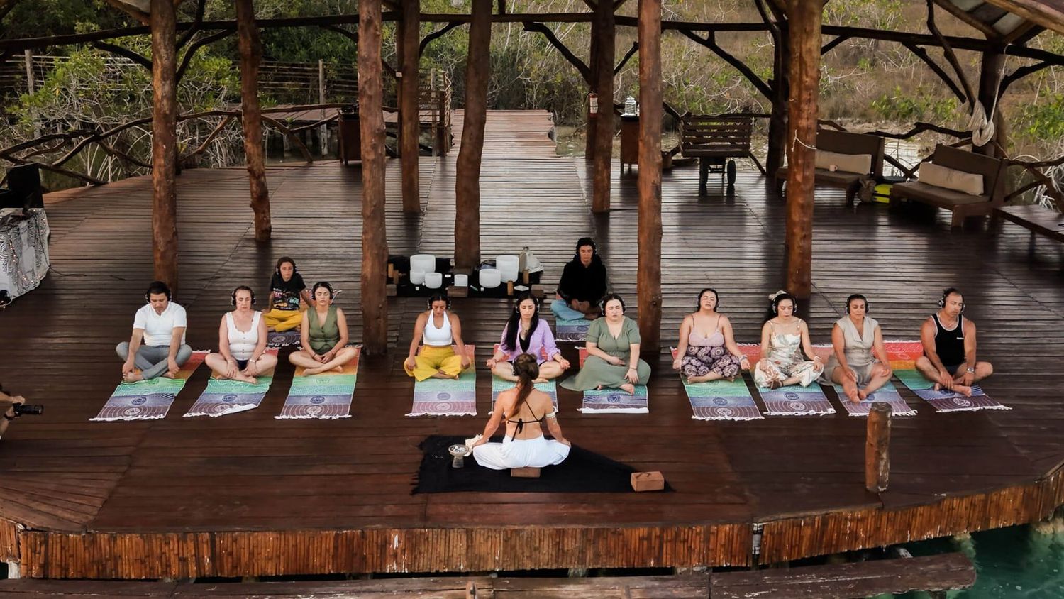 Sesión de sound healing con cuencos sobre el deck de madera, frente a la laguna